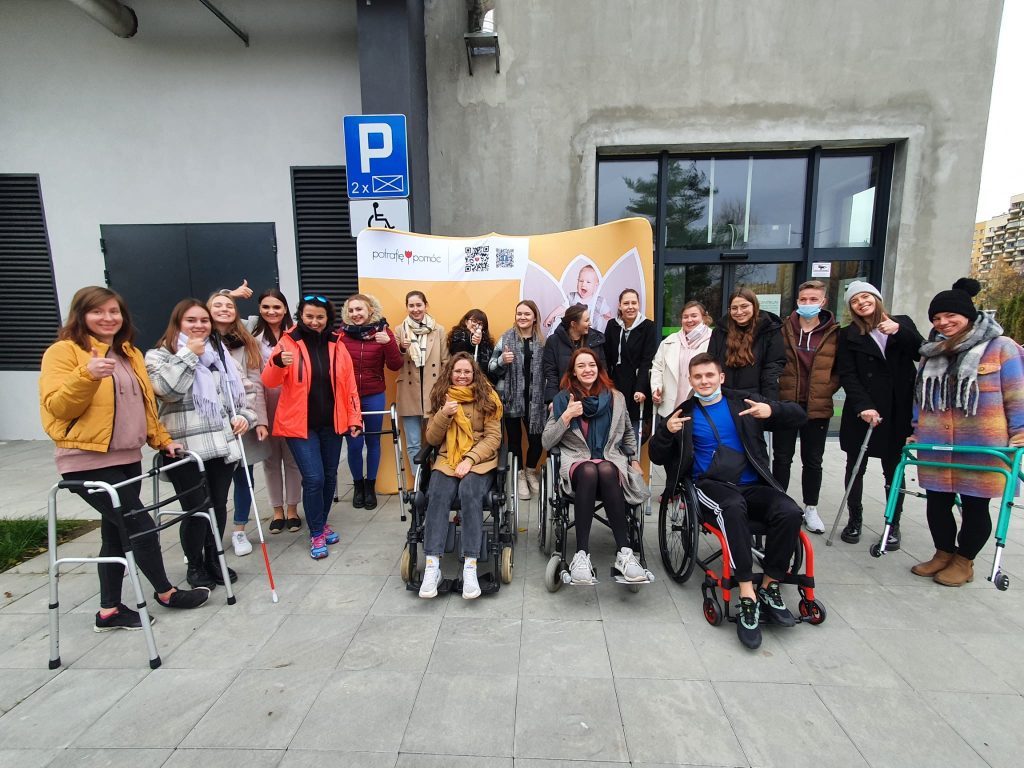 grupa osób niepełnospraawnych przed budynkiem