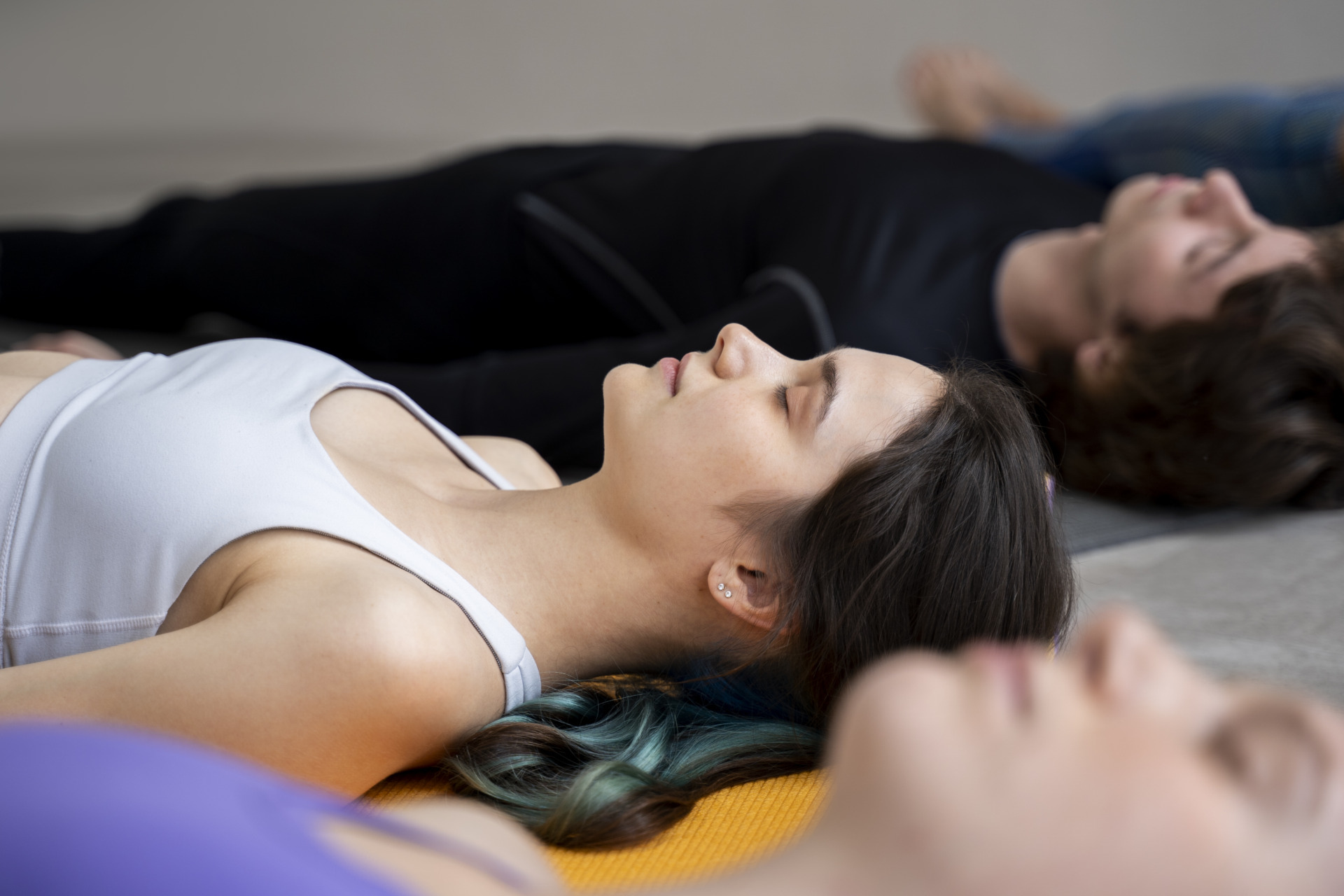 Ludzie leżą z zamkniętymi oczami podczas yogi
